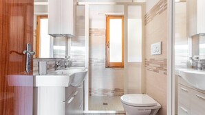 Un baño moderno con ducha, inodoro y lavabo.