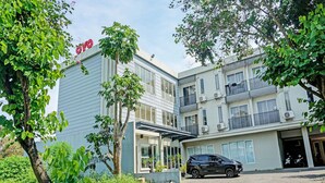 A modern building with a sign reading "OYO" and a black car parked in front. - Collection O 91288 Chrysant Premiere Residence (Malang)