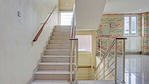 A staircase with metal railings and a plain wall. - Collection O 91288 Chrysant Premiere Residence (Malang)
