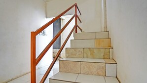 Een trap met een houten leuning en stappen van beige marmer.