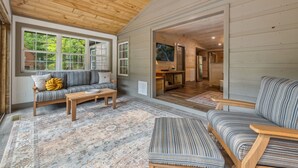 A cozy living room with a wooden ceiling, a sofa, a coffee table, and a patterned rug. - The River's Edge (Blue Ridge)