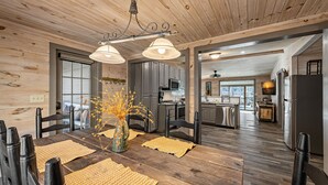 A modern kitchen with dark cabinets, a stainless steel refrigerator, and a microwave. - The River's Edge (Blue Ridge)