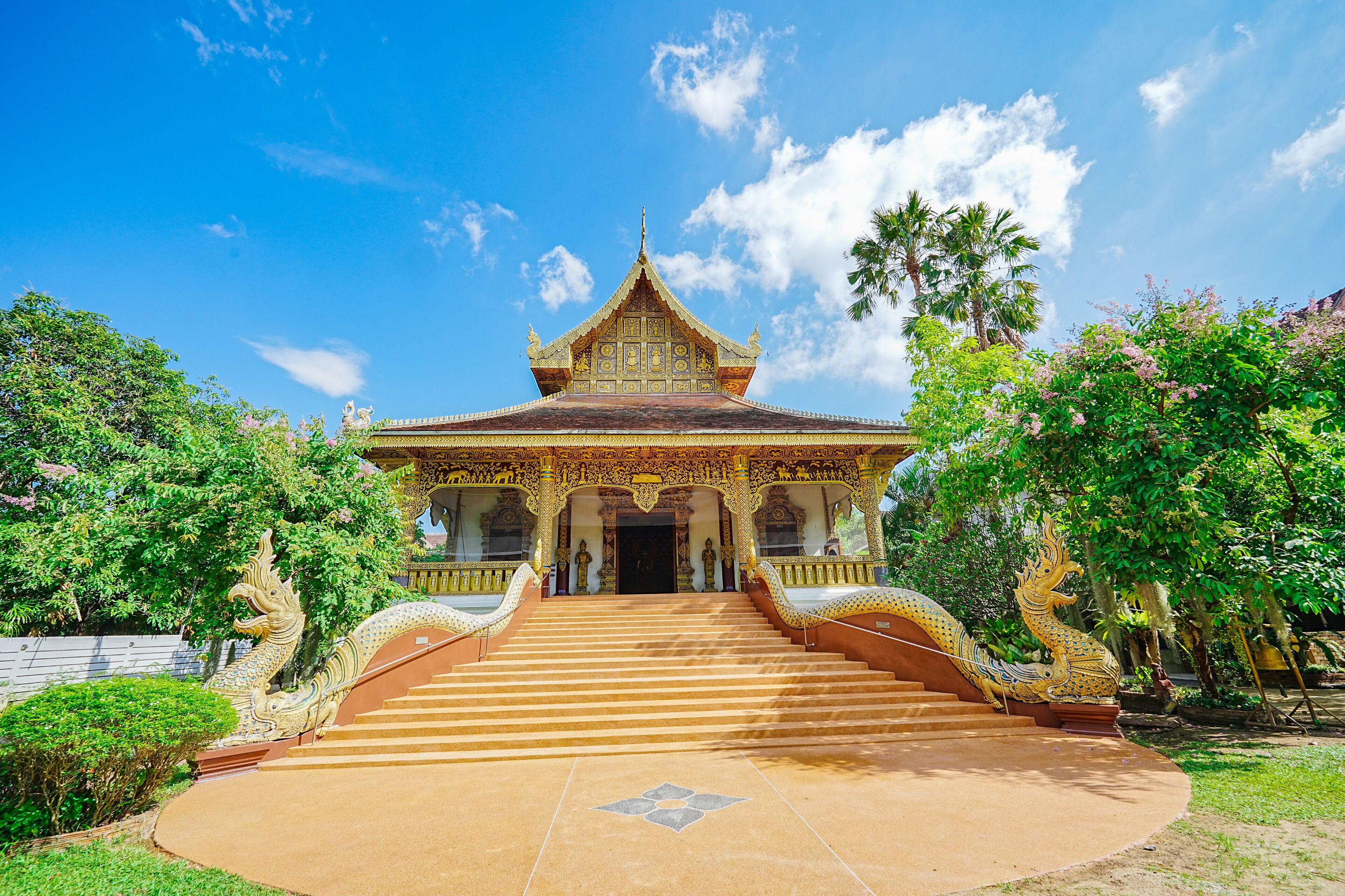 A traditional temple with ornate architecture, a central entrance, and a staircase leading up to it.