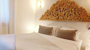 Una cama con cabecera, almohadas y una mesita de noche.