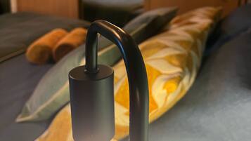 Ein Nahblick auf eine moderne Lampe mit gebogenem Lampenschirm und einer Glaskuppel, die eine Glühbirne beherbergt.