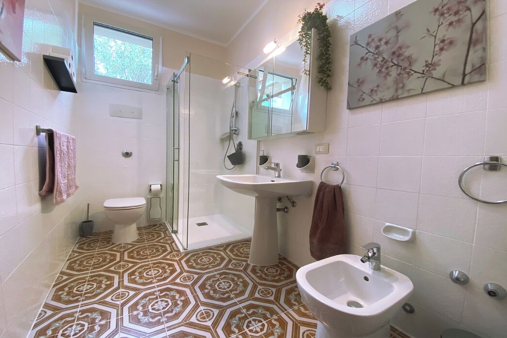Une salle de bain équipée d’une douche, de toilettes, d’un bidet et d’un lavabo.