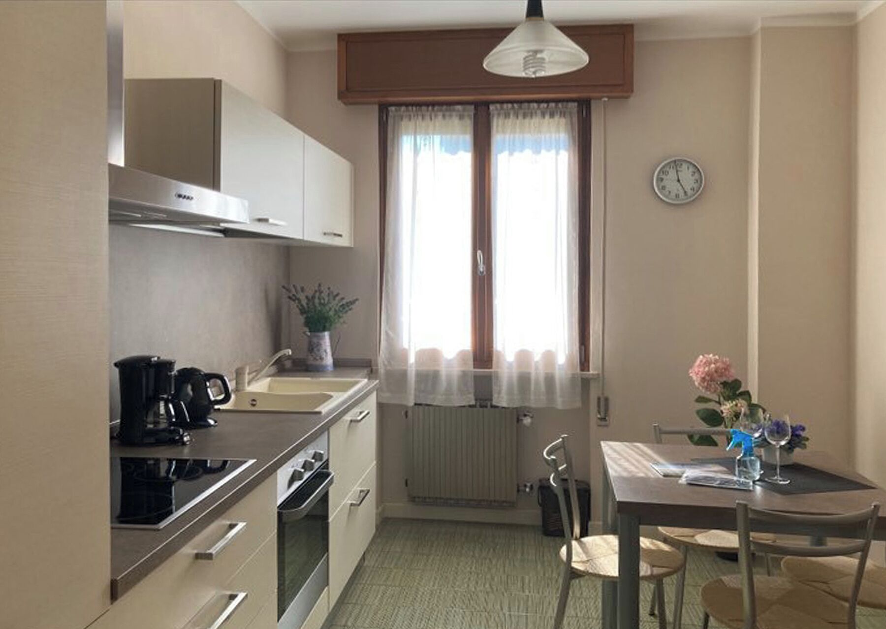 Une cuisine compacte équipée d’une cuisinière, d’un évier et d’un coin repas avec une table et des chaises.
