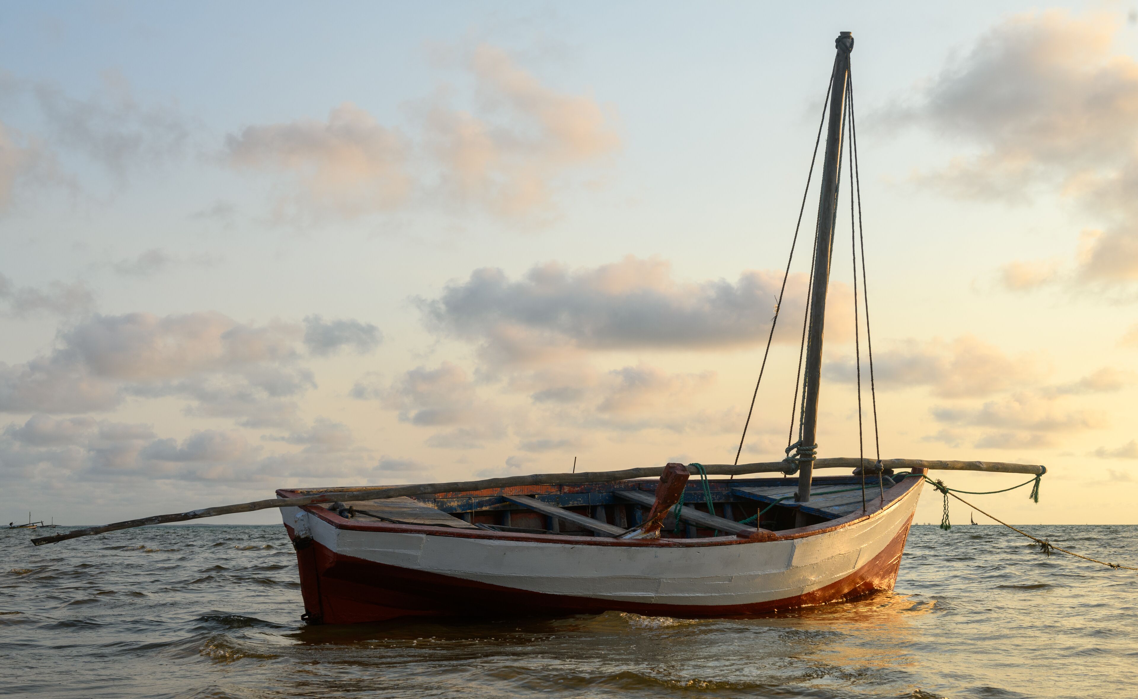 Un bote anclado en aguas tranquilas con un cielo despejado al fondo.