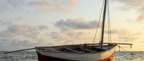 Un bote anclado en aguas tranquilas con un cielo despejado al fondo.