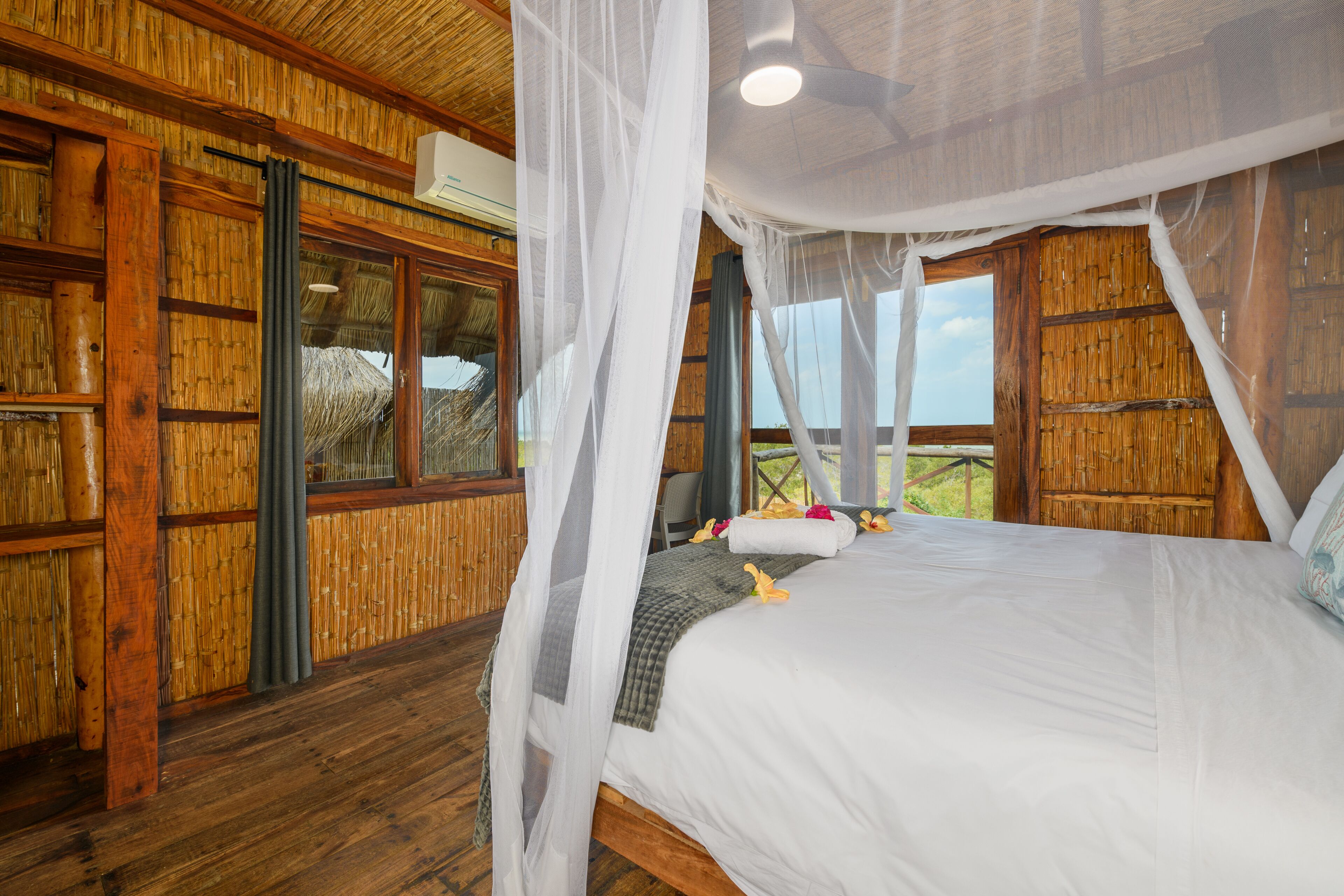 A room with a bed, wooden walls, and windows.