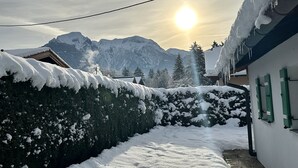 A snowy mountain landscape with a house and a clear sky.