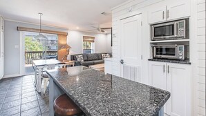 A modern kitchen with granite countertops, white cabinetry, and built-in appliances.