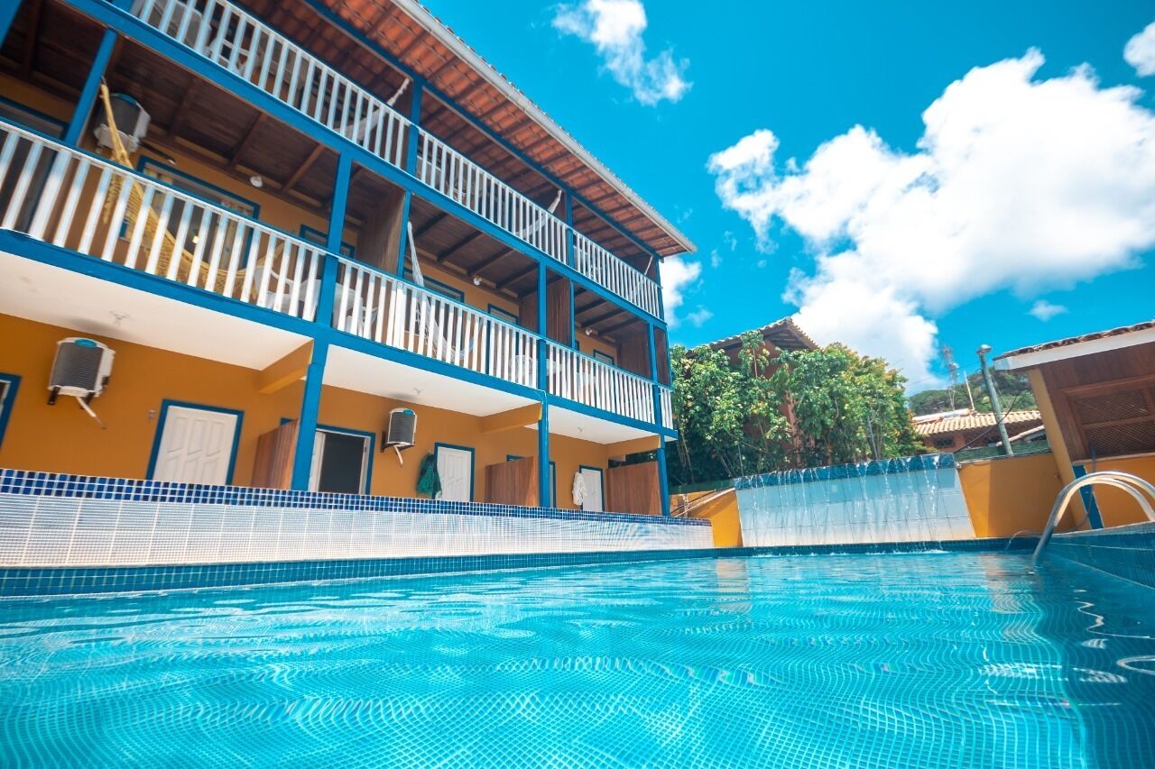 Una piscina con un edificio de varios niveles al fondo.