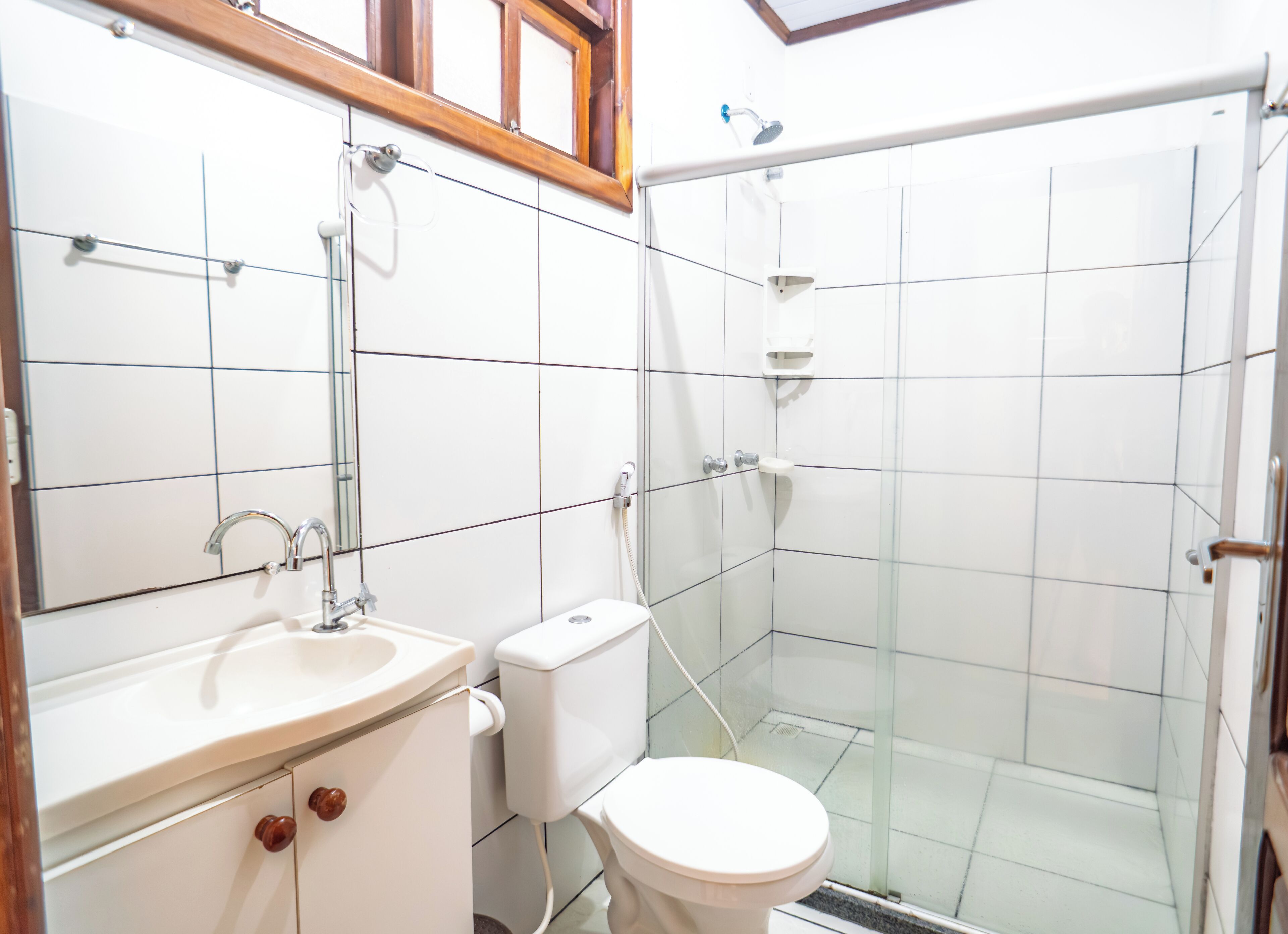 A bathroom with a sink, toilet, and glass-enclosed shower area.