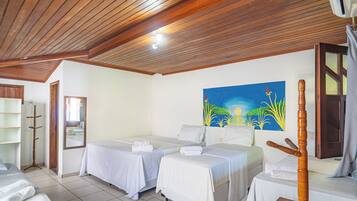 A hotel room with two beds, a wooden ceiling, a painting on the wall, and a mirror.