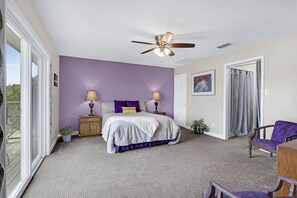 A bedroom with a bed, two bedside lamps, a ceiling fan, a window, and a chair. - Painted Paradise Main House I Private Pool I Lake Nearby (New Braunfels)