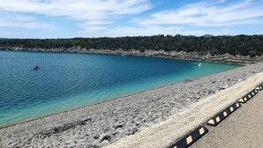 Una strada costiera con una spiaggia rocciosa e un mare cristallino.