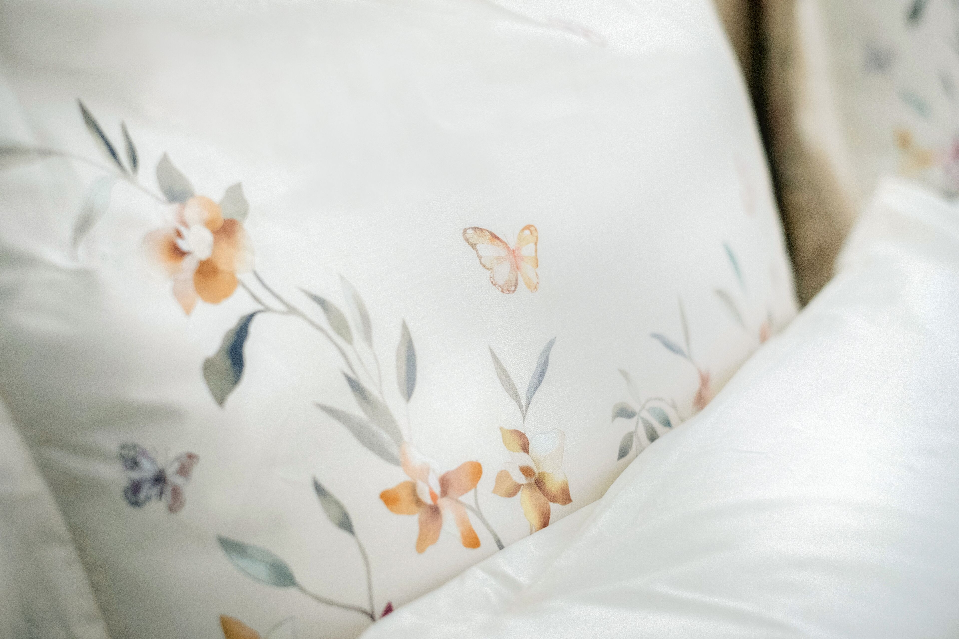 Un almohadón con diseño floral y de mariposas.