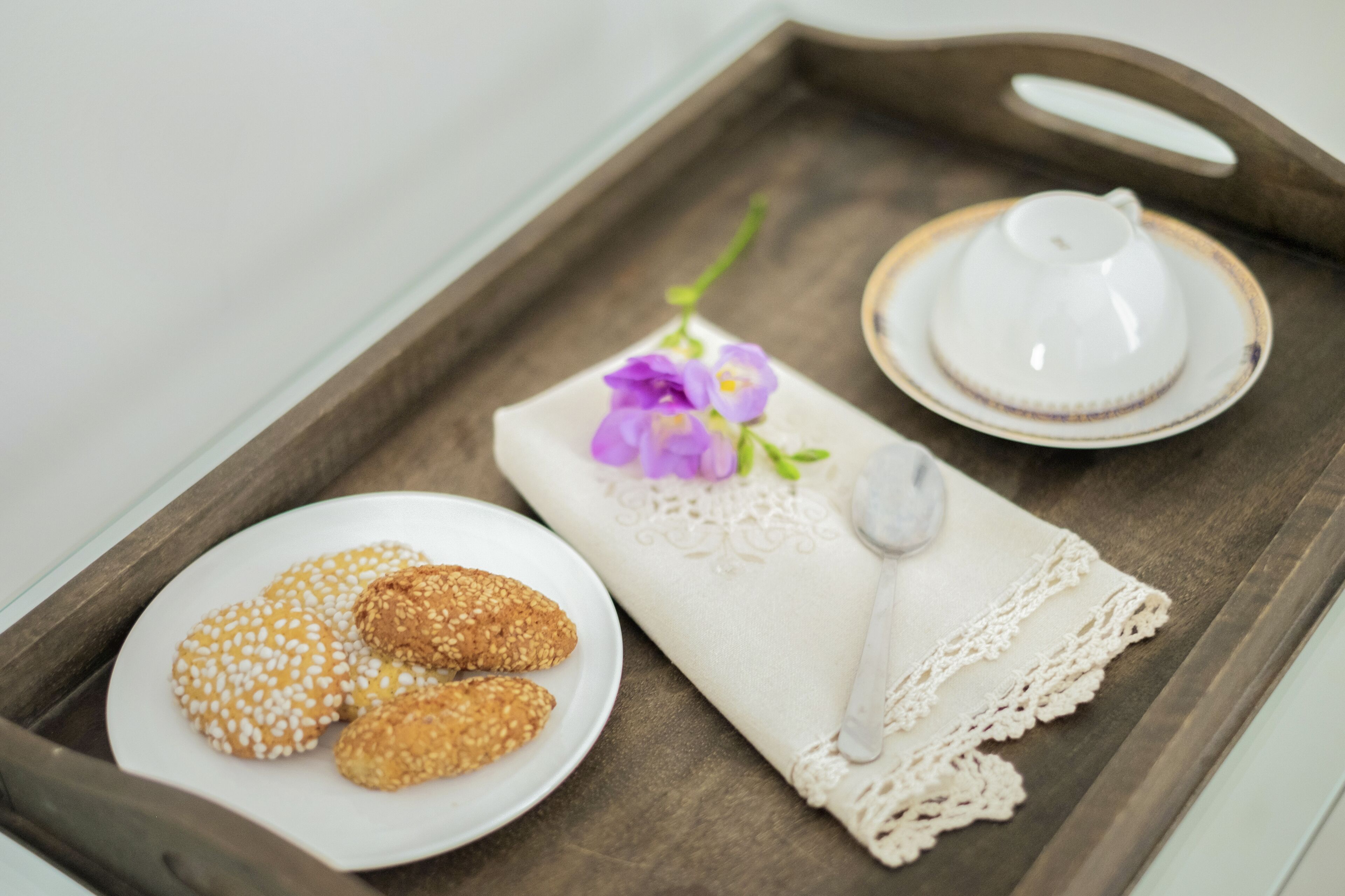 Ein Tablett mit Keksen, einer Teetasse und einer Serviette mit einem Blumenmuster.