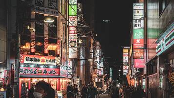 A busy urban street at night with illuminated signs and buildings.