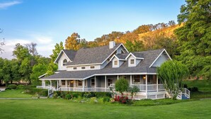 A large, two-story house with a wrap-around porch and a well-maintained lawn. - 20 Acres + Pool + Game Room | Paso Wine Country | Oaks and Roses Ranch (Paso Robles)