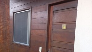 Une porte en bois avec une plaque portant le numéro « 5 » et une fenêtre au-dessus.