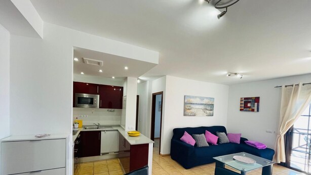 Un appartement moderne comprenant une cuisine, un coin repas et un salon.