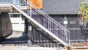A multi-story building with a balcony, a staircase, and a gated entrance. - Yamba Views Apartment (Yamba)