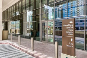 A modern building entrance with glass doors and a sign indicating the Main Entrance Lobby and Tower 2.