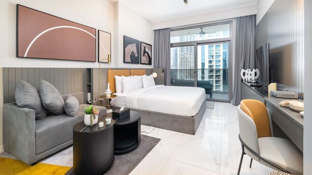 Une chambre d’hôtel moderne équipée d’un grand lit, d’un canapé, d’un bureau et d’une télévision.