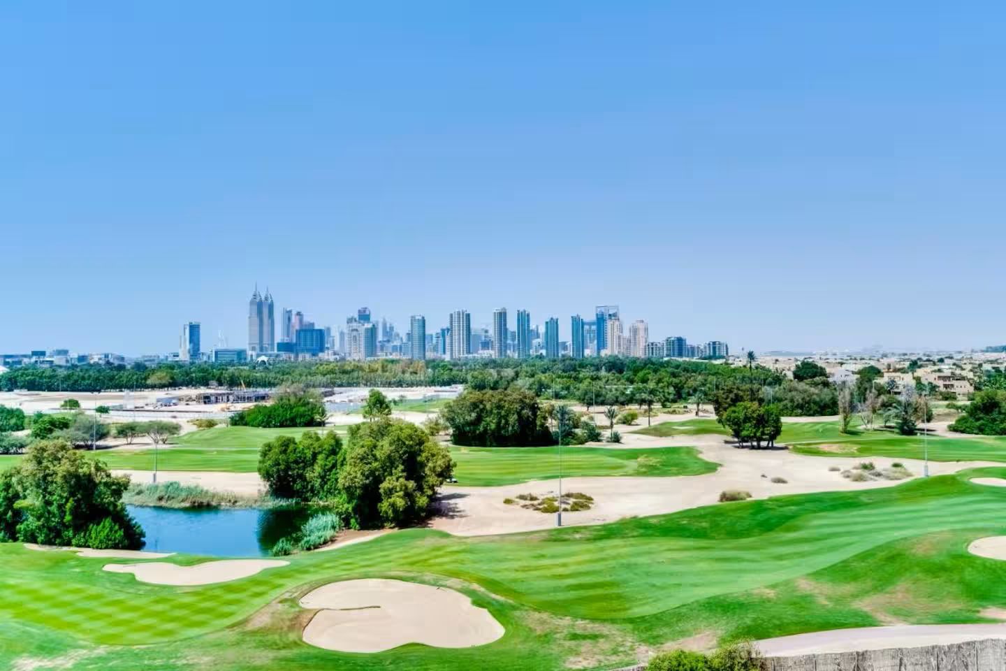 A golf course with a city skyline in the background.