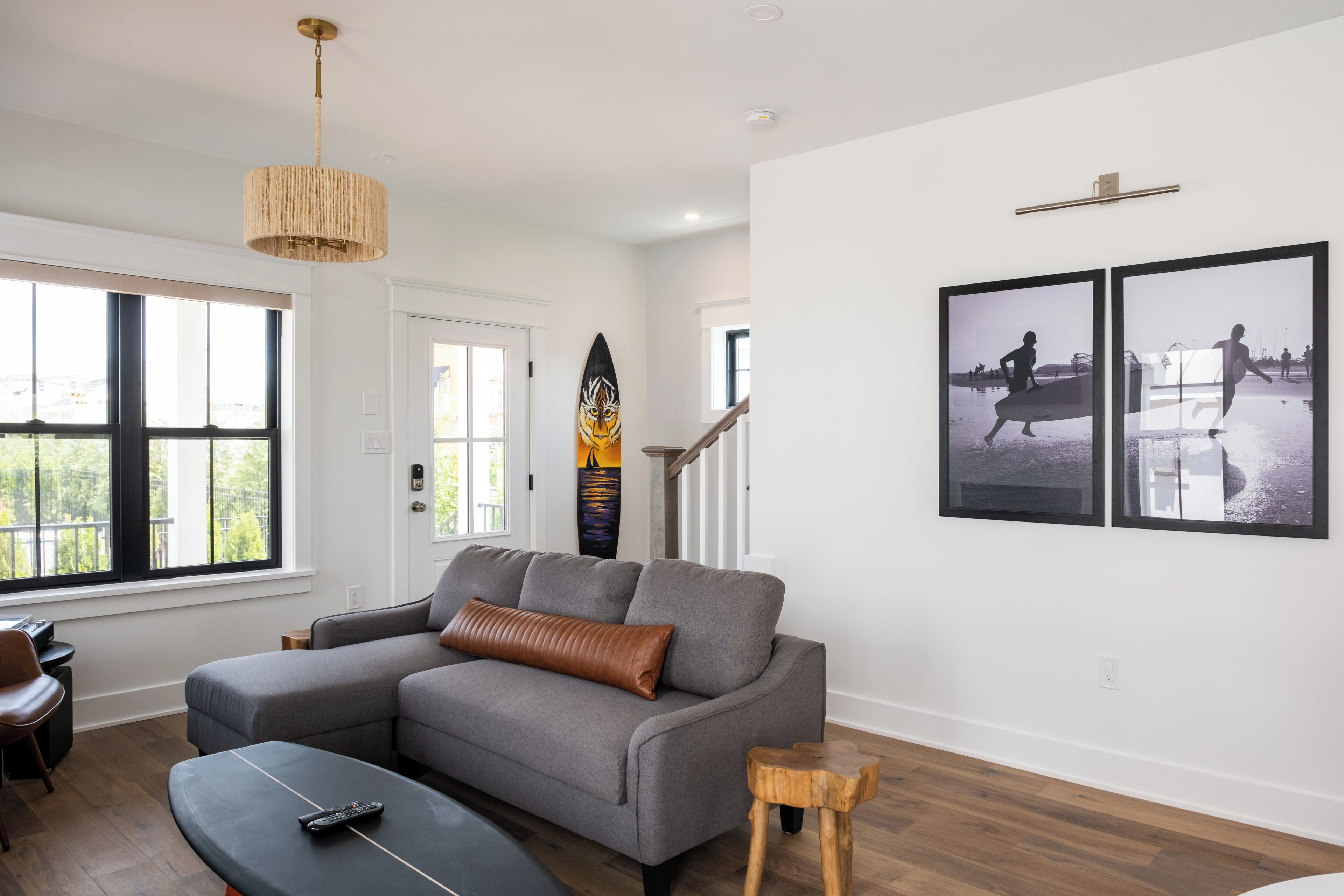 A modern living room with a grey sofa, a wooden coffee table, and a large window.