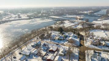 An aerial view of a residential area with houses, a bridge, and a river.