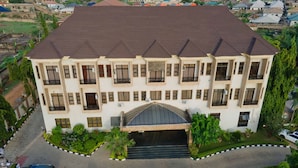 A multi-story building with a flat roof, multiple balconies, and a central entrance with steps. - Princess Luxury Hotels (Ilorin)