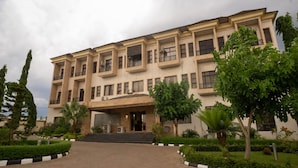 A multi-story building with a symmetrical facade, multiple balconies, and a central entrance with steps. - Princess Luxury Hotels (Ilorin)