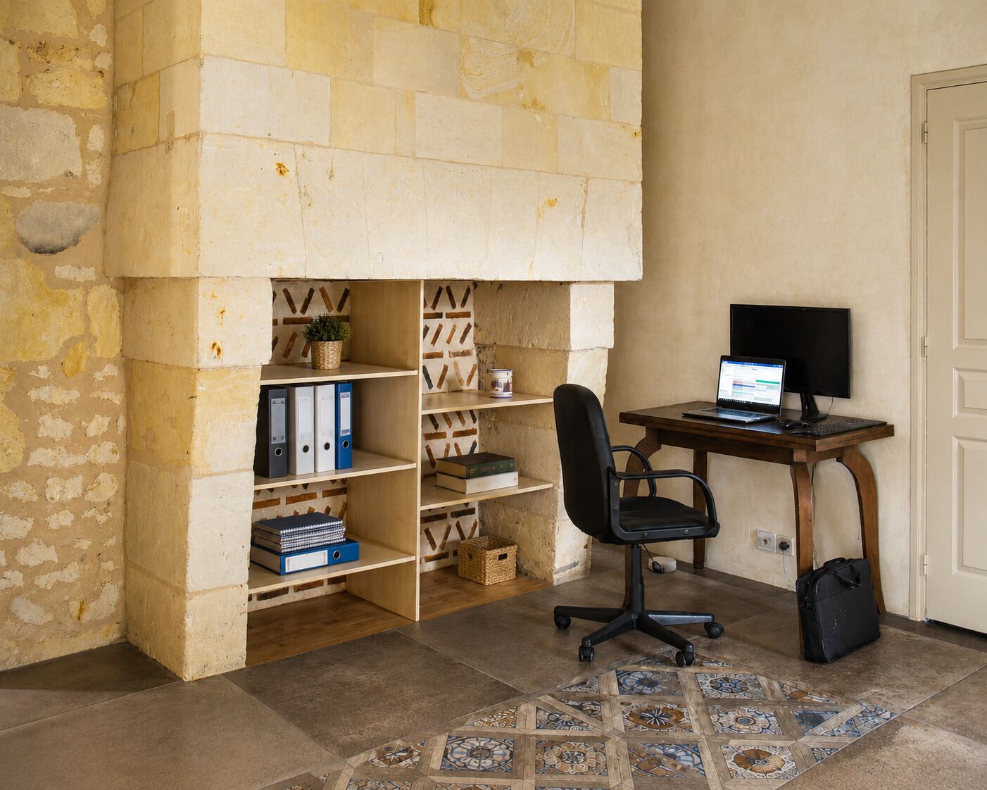 A room with a desk, chair, and bookshelf.
