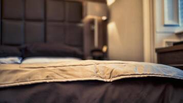 A bed with a headboard, a bedside table, and a lamp.