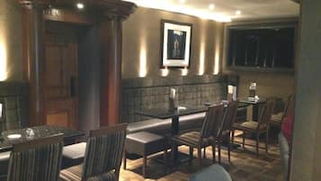 A restaurant with a wooden interior, cushioned booths, and a stone wall.