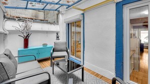 A compact living space with a glass table, grey sofa, and a blue cabinet. - Hippolyte - Appt avec terrasse couverte (Toulouse)