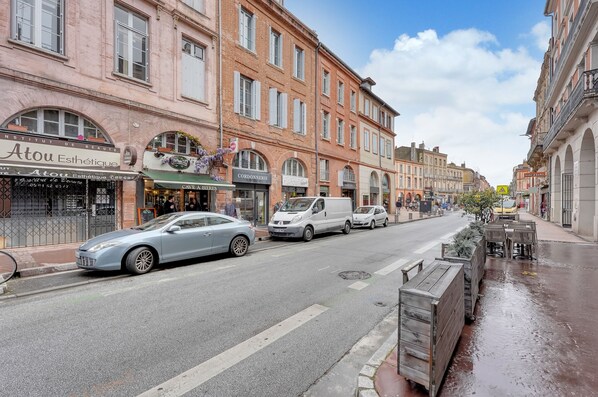 A street with buildings, a car, and a van. - Hippolyte - Appt avec terrasse couverte (Toulouse)