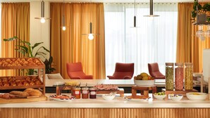 Ein Frühstücksbuffet mit Backwaren, Früchten und Beilagen.