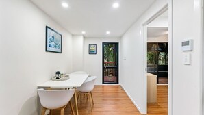 A modern kitchen with white cabinetry, a wooden countertop, and a built-in oven.