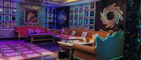 A room with a checkered floor, a red sofa, a blue sofa, and a table with various items.