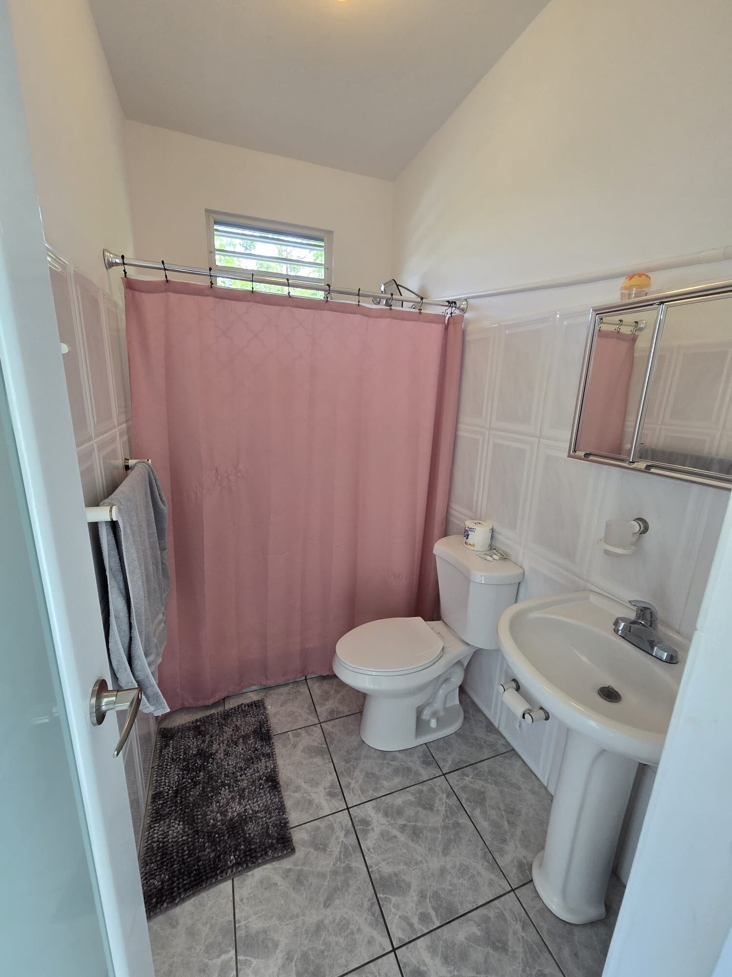 A bathroom with a toilet, sink, and shower curtain.