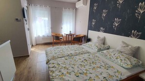 Et soveværelse med seng, et lille bord og en stol.