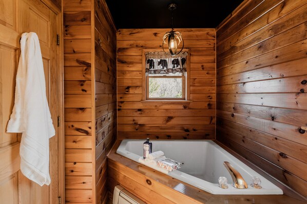 A wooden cabin bathroom with a bathtub, a towel hanging on the wall, and a window with curtains. - Catskills Cabin Rental Only 2.5 Hours Away From NYC! (Downsville)
