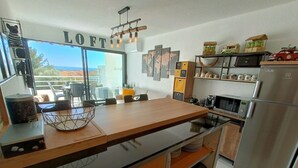 Eine moderne Küche mit Kochinsel, Edelstahlgeräten und Blick ins Freie.