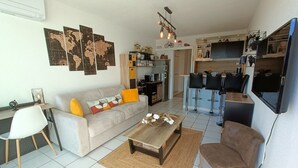 Ein modernes Wohnzimmer mit Sofa, Couchtisch und einem Essbereich mit Stühlen.