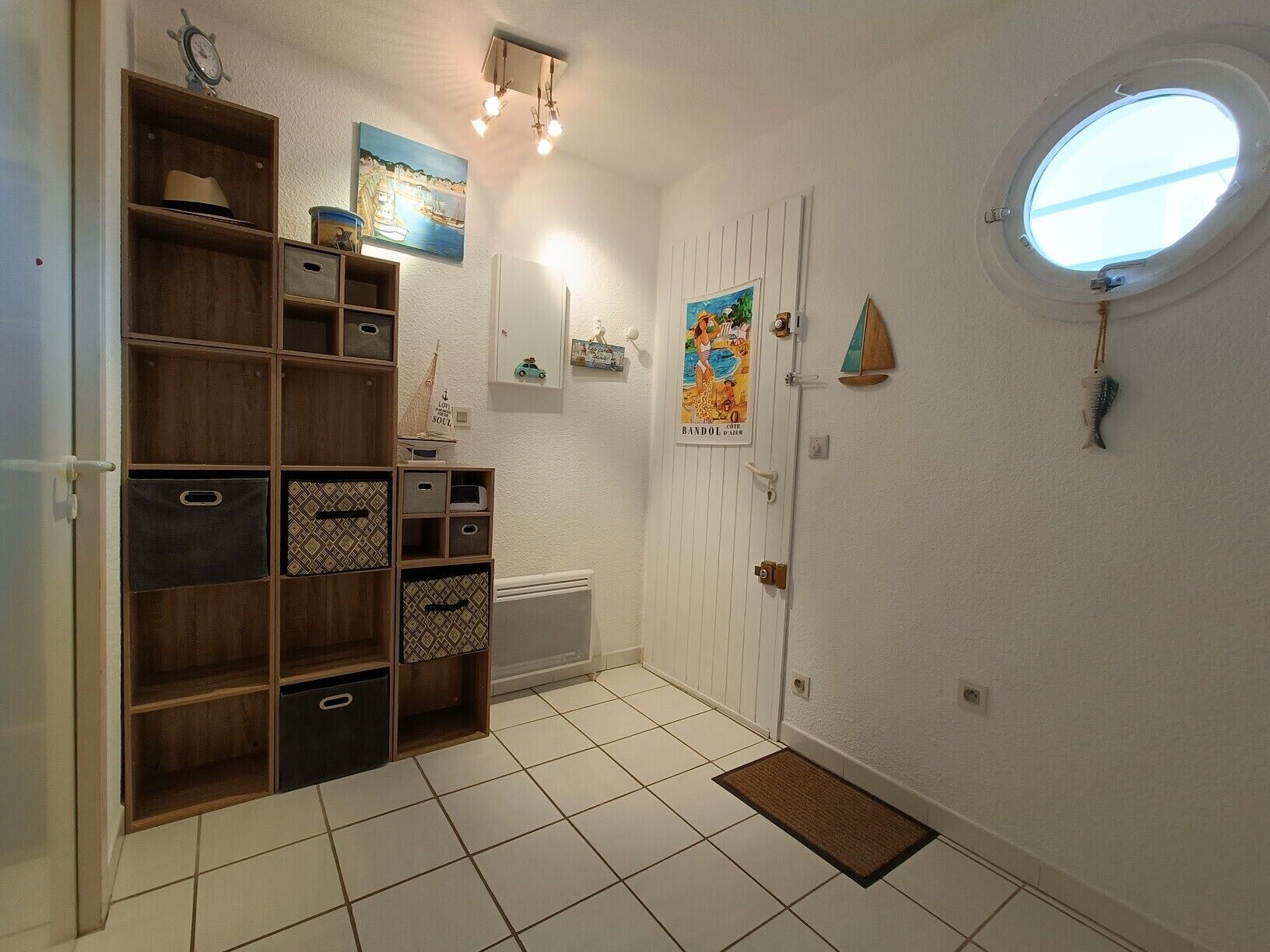 A hallway with a white door, a small window, and a shelf unit with storage bins.