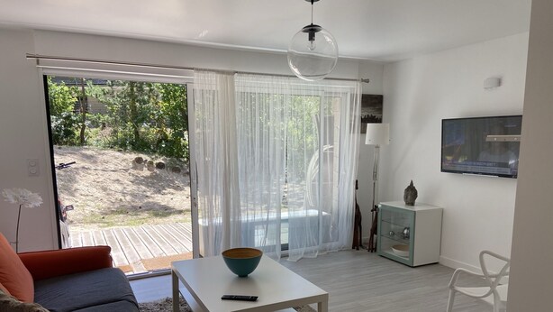 Un salon moderne avec un canapé, une table basse et un téléviseur.